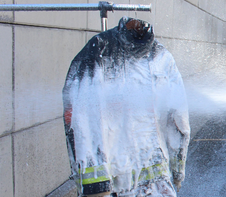 Bunker gear being sprayed with decon foam